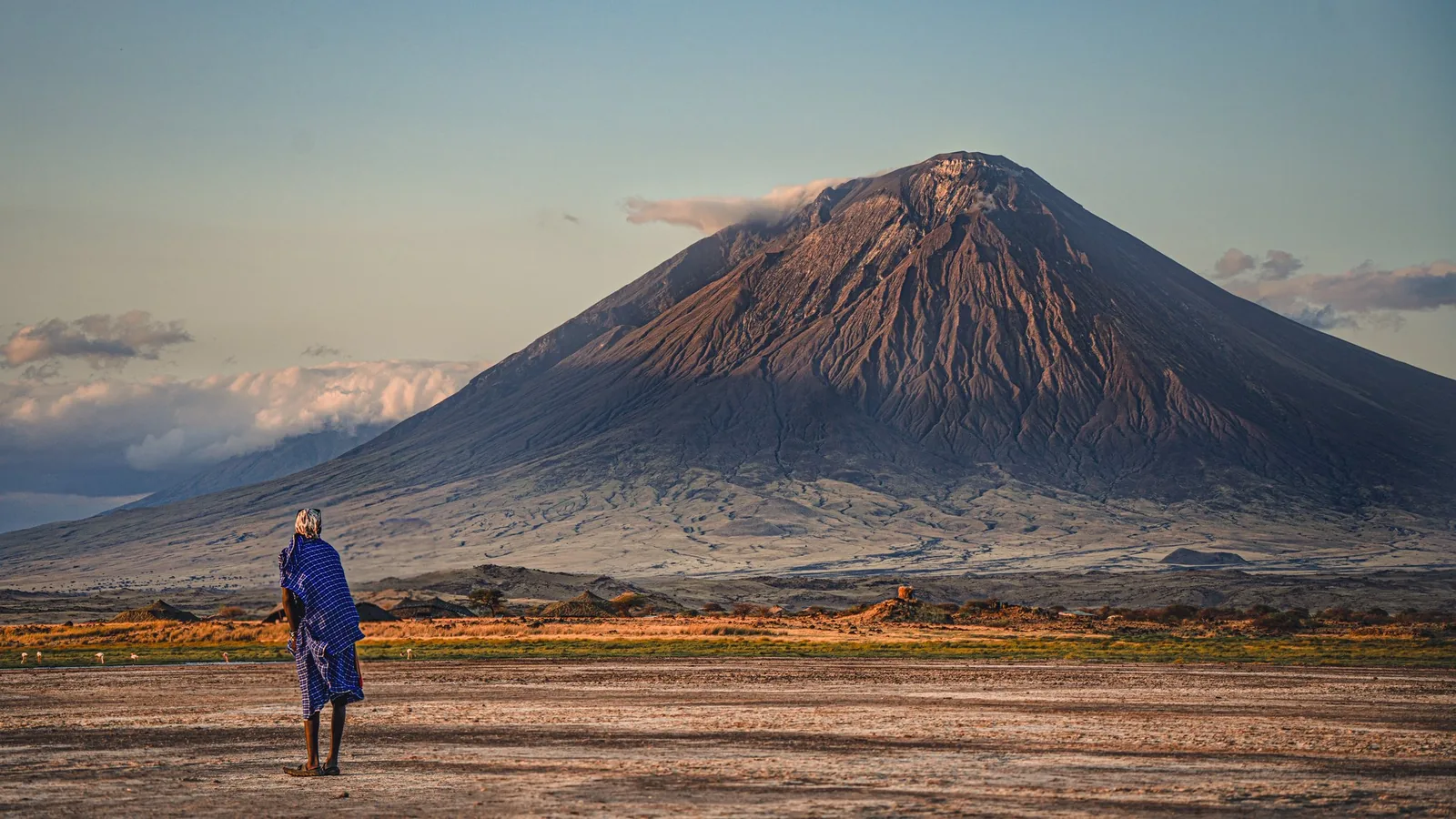 Hombre maasai observando el volcán Ol Doinyo Lengai desde el lago Natron, Tanzania